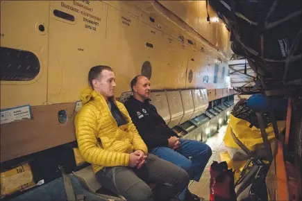  ?? TAMARA MERINO / THE NEW YORK TIMES ?? Louis Rudd, right, and Colin O´brady sit on the airplane Oct. 30 in Punta Arenas, Chile, on their departure day to Union Glacier, Antarctica. O’brady and Rudd are both trying to become the first to finish the 921-mile odyssey on ice completely unsupporte­d. It is a journey that killed a man who tried two years ago.