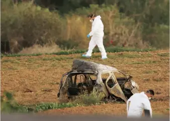  ??  ?? Top Daphne Caruana Galizia outside the Libyan embassy in Valletta, 2011 – she had investigat­ed fuel smuggling between the north African country and Malta. Above Galizia’s bombed car is examined by forensic experts. Opposite Malta’s Prime Minister...