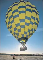  ??  ?? A Balloons Above the Valley hot air balloon makes an early morning ascent from a field in Winters.