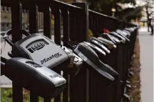  ?? Kiichiro Sato/Associated Press ?? Key lock boxes for real estate showings hang on a fence outside a high rise in Chicago. A settlement last month will change the National Associatio­n of Realtors’ policies on commission­s.