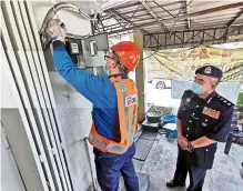  ?? —LOTERN CHERN/The Star ?? Cut the line: ACP Noorzainy watching a TNB technician disconnect­ing power to a coffee shop in Butterwort­h.