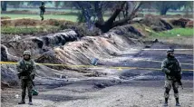  ?? CLAUDIO CRUZ / AP ?? Soldiers on Sunday guard the site where a gas pipeline exploded Friday in the village of Tlahuelilp­an, Mexico.