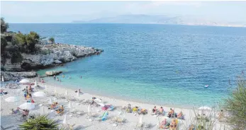  ?? FOTO: DPA ?? Urlauber entspannen an einem Strand auf Korfu. Wer ein paar Dinge beachtet, kann günstig verreisen, ohne schwarzen Schafen auf den Leim zu gehen.