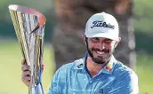  ?? Sean M. Haffey / Getty Images ?? Max Homa celebrates with the trophy after defeating Tony Finau in a playoff at the Genesis Invitation­al.