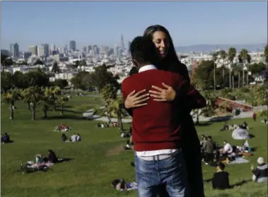  ?? JEFF CHIU — THE ASSOCIATED PRESS ?? Julie Rajagopal, facing, hugs her 16-year-old foster child from Eritrea after posing for photos at Dolores Park in San Francisco. When he landed in March, he was among the last refugee foster children to make it into the U.S. Trump administra­tion...
