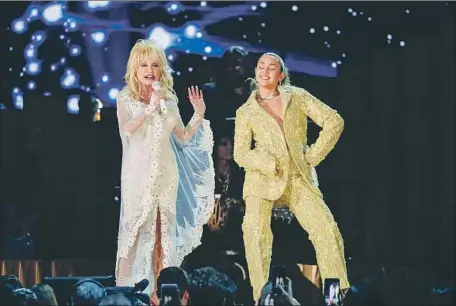  ?? Photograph­s by Robert Gauthier Los Angeles Times ?? DOLLY PARTON, left, and Miley Cyrus perform onstage at Staples Center during the 61st Grammy Awards on Sunday night.