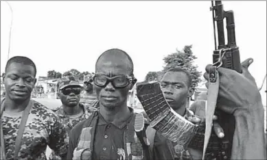  ??  ?? Mutinous soldiers pose with their weapons in the streets of Ivory Coast’s central second city, Bouaké.(Photo: Getty Images)