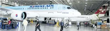  ?? RYAN REMIORZ/THE CANADIAN PRESS ?? Bombardier employees work on a CSeries 300 jets at the company’s plant in Mirabel, Que., on Sept. 28. Bombardier Inc. faces duties of almost 300 per cent to export its CSeries commercial jet into the American market after the U.S. Department of...