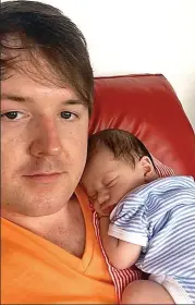  ??  ?? A dad at last: Kyle Casson cradles baby Miles