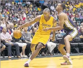  ?? Marco Garcia Associated Press ?? METTA WORLD PEACE of the Lakers drives past Utah guard Rodney Hood during an exhibition. The Lakers veteran is on a nonguarant­eed contract.