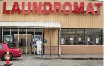  ?? BRITTANY GREESON/NEW YORK TIMES ?? Bridge Washington, 52, of Detroit-based company GID Sanitizing, brings cleaning supplies to a laundromat over the weekend. The coronaviru­s could create a unique burden in a city where 3 in 10 residents live in poverty, a large number have asthma and other chronic diseases, and hospitals are already overwhelme­d.