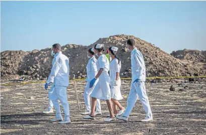  ?? MULUGETA AYENE THE ASSOCIATED PRESS ?? Nurses collect materials Tuesday as part of the investigat­ion at the scene of the Ethiopian Airlines Boeing 737 Max 8 crash.