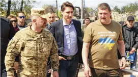  ?? IRPIN MAYOR’S OFFICE VIA AP ?? Canadian Prime Minister Justin Trudeau (center) walks with mayor Oleksandr Markushyn (right) in Irpin, Ukraine, on Sunday. Trudeau made a surprise visit to the severely damaged city on Sunday.