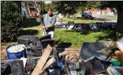  ??  ?? Josh Herrera puts ruined items on his lawn Saturday in Millburn, New Jersey, in the wake of last week’s flooding. After seeing water rising from street sewer grates, he, his wife and children waded waist deep to flee their home.