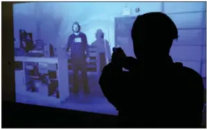  ?? Arkansas Democrat-Gazette/THOMAS METTHE ?? Little Rock Police cadet Eboney Warren points her gun at a suspect while running a simulation Friday at the Little Rock Police Training Academy. Cadets and certified officers receive training on de-escalating encounters to help cut down on use-of-force...