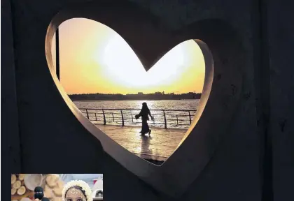  ?? HASAN JAMALI/THE ASSOCIATED PRESS ?? A Saudi woman seen through a heart-shaped statue walks along an inlet of the Red Sea in Jiddah, Saudi Arabia.