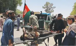  ?? — AFP ?? Afghan men carry a victim of a powerful car bomb in Lashkar Gah, the capital of Helmand province, on Thursday.