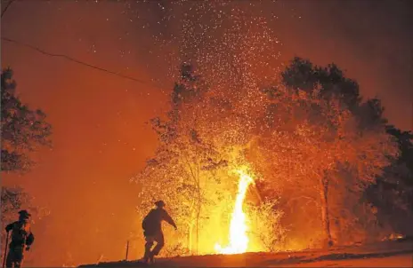  ?? Josh Edelson/AFP/Getty Images ?? Firefighte­rs monitor a backfire Friday during the Carr fire in Redding, Calif.