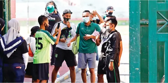  ?? ANGGER BONDAN /JAWA POS ?? LAMA
TAK JUMPA: Irfan Jaya (dua dari kanan) dan Oktafianus Fernando dicegat suporter untuk minta foto bersama sebelum berlatih kemarin.