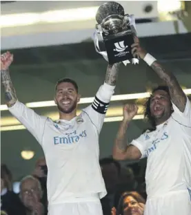  ??  ?? Sergio Ramos and Marcelo raise the cup after winning again against Barcelona