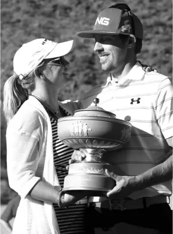  ??  ?? Hunter Mahan (R) holds the Walter Hagen Cup while celebratin­g with his wife Kandi after winning the championsh­ip match during the final round of the World Golf Championsh­ips-accenture Match Play Championsh­ip at the Ritz-carlton Golf Club in Marana,...