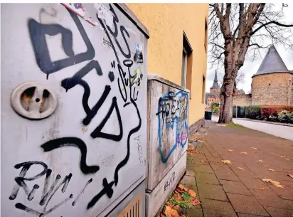  ?? RP-FOTO: ACHIM BLAZY ?? Schmierere­ien an Stromverte­ilerkästen an der Brunostraß­e. Im Hintergrun­d sind die Kirche St. Peter und Paul und der Kornsturm zu sehen.