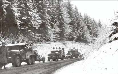  ?? AP Photo/U.S. Army Signal Corps ?? In this photo provided by the U.S. Army Signal Corps, part of a U.S. Army convoy to the front line stops for rest in a beautiful snowcovere­d valley in Belgium, Dec. 22, 1944, during the Battle of the Bulge. The men are reinforcem­ents for units in the front lines holding back the German counter-thrust.