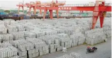  ??  ?? Workers ride on a motor rickshaw through an aluminium ingots depot in Wuxi, Jiangsu province, China. — Reuters