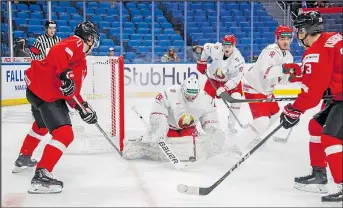  ?? THE CANADIAN PRESS ?? Against a backdrop of empty seats at the Keybank Center in Buffalo, Switzerlan­d battles Belarus in opening-round action at the world junior championsh­ip yesterday.