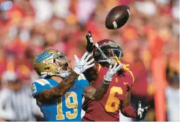  ?? MARK J. TERRILL/AP ?? UCLA running back Kazmeir Allen, left, makes a touchdown catch as USC cornerback Isaac Taylor-Stuart defends during the rivals’ 2021 meeting.