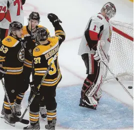  ?? STAFF PHOTO BY NANCY LANE ?? PARTY LINE: David Pastrnak (back) celebrates a goal yesterday with Brad Marchand (63) and Patrice Bergeron as Senators goalie Mike Condon reacts. The trio combined for 11 points on the day as the Bruins rolled to a 6-3 victory in their home opener.