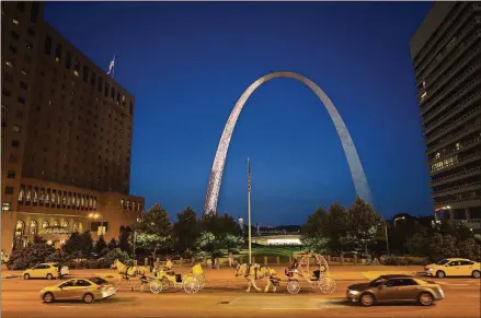  ?? MATT MILLER FOR THE WASHINGTON POST PHOTOS ?? Horse-drawn carriages and cars share the road near the Gateway Arch near the Mississipp­i River in downtown St. Louis. The Arch features a new museum and visitors center, scheduled to open July 3.