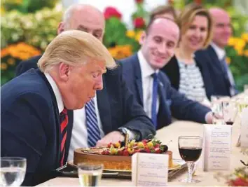  ?? AFP ?? Trump blows out a candle on a cake inscribed with ‘Celebratin­g birthday, a bit early’, during a working lunch with Singapore’s Prime Minister Lee Hsien Loong. Trump turns 72 on Thursday.