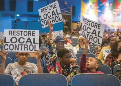  ?? ANDY LAVALLEY/POST-TRIBUNE ?? Kahlil Byrd, left, is joined by his brothers Kamryn and Shalon in holding signs during Wednesday’s meeting at the Gary West Side Leadership Academy.