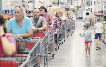  ?? Joe Burbank / Orlando Sentinel via Associated Press ?? Shoppers wait in line to get two cases of bottled water — the limit per customer — at the Costco store in Altamonte Springs, Fla., on Friday as central Florida residents prepare for a possible strike by Hurricane Dorian.