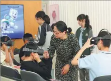  ?? PROVIDED TO CHINA DAILY ?? From left: Teachers guide students in using virtual reality headsets during a training session at a center dedicated to students’ mental health in Jiaxing, Zhejiang province, in May.