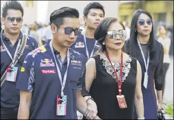  ??  ?? Vorayuth “Boss” Yoovidhya (second left) whose grandfathe­r co-founded energy drink company Red Bull, walks with his mother Daranee (second right) at the Formula 1 Grand Prix in Abu Dhabi. Vorayuth is accused of killing a Thai police officer in a...