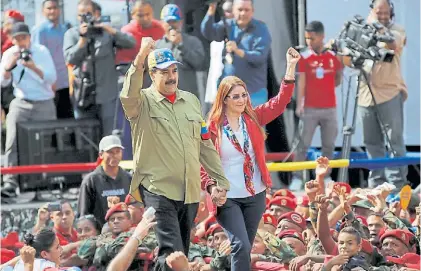  ?? EFE ?? Saludos. El presidente Maduro y su mujer, Cilia Flores, durante una marcha chavista en Caracas.