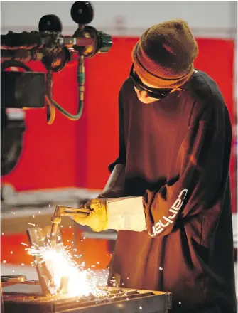  ??  ?? Kelsey Clarke, 22, a Level 2 apprentice welder, works in the new trades building at Interurban campus.