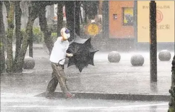  ?? KYODO NEWS PHOTOS VIA AP ?? A man is drenched by the rain from Tropical Storm Meari in Hamamatsu, Shizuoka prefecture, central Japan on Saturday.