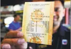  ?? JIM GENSHEIMER — STAFF PHOTOGRAPH­ER ?? Ruby Singh holds a copy of the winning lottery numbers at the Chevron on California Circle in Milpitas, which sold the five-number Powerball winner and a $425 million winner in 2014.