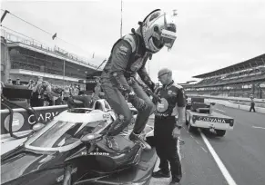  ?? DARRON CUMMINGS/AP ?? Jimmie Johnson gets out of his car following practice for an Indycar race Aug. 13 at Indianapol­is Motor Speedway.