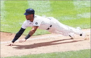  ?? Mike Stobe / Getty Images ?? The Yankees’ Aaron Hicks dives back to third base safely in the second inning against the Tigers on Sunday.