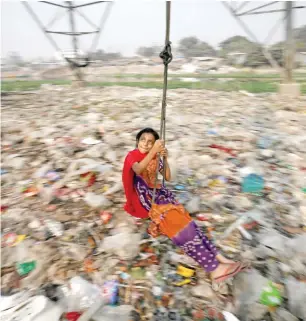  ?? SWINGING HOPES: — Reuters ?? A Bangladesh­i girl plays on a swing in Dhaka on Tuesday.