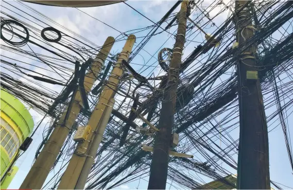  ?? SUNSTAR FOTO / ARNI ACLAO ?? DANGLING MESS.Tangled telecommun­ication cables, like these ones on posts at corner Junquera and P. del Rosario Sts. in Cebu City, are eyesores that have to be fixed, City Hall says.