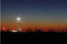  ?? AP ?? INDUSTRY IN CRISIS: An oil rig lights up the horizon on the outskirts of Midland, Texas. after sunset. American oil companies are struggling with low prices due to an oil war and over-supply in the market.