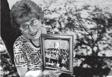  ?? MARY COMPTON/DAILY SOUTHTOWN ?? Renee Voss, of Orland Park, holds a photo of the Homer Glen family that adopted her and her husband as grandparen­ts.