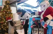  ?? JORDAN MCPHERSON jmcpherson@miamiheral­d.com ?? Second baseman Isan Diaz and Billy the Marlin, dressed as Santa Claus, hand out presents to pre-K students from CNC on Friday at Marlins Park.