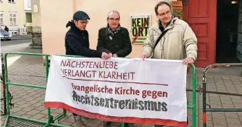  ?? FOTO: DPA ?? Pfarrer Michael Kleim (Mitte) aus Gera beim Vorbereite­n einer Mahnwache gegen Rechts. Die Reportage „Kreuz ohne Haken – Die Kirche und die Rechten“geht der Frage nach, wie sich die Kirche gegen Neo-Nazis positionie­rt.