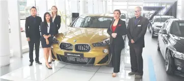  ??  ?? Tay (third left) and the Regas Kuching branch sales agents alongside the new BMW X2 in galvanic gold metallic.